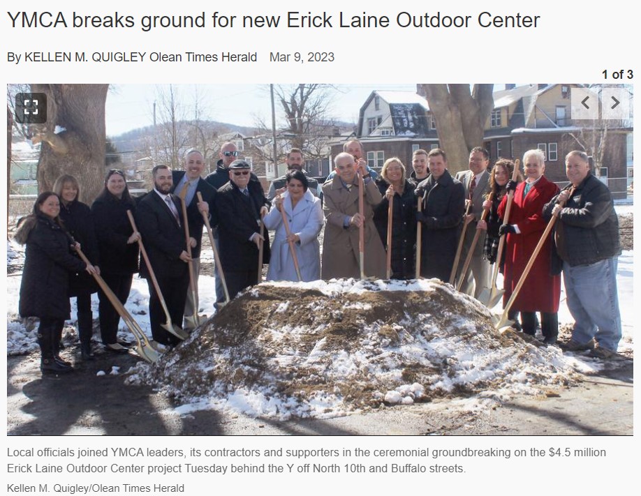 twenty people with shovels next to a mound of dirt on a construction site